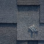 Close,up,view,on,asphalt,roofing,shingles,and,nails,background.