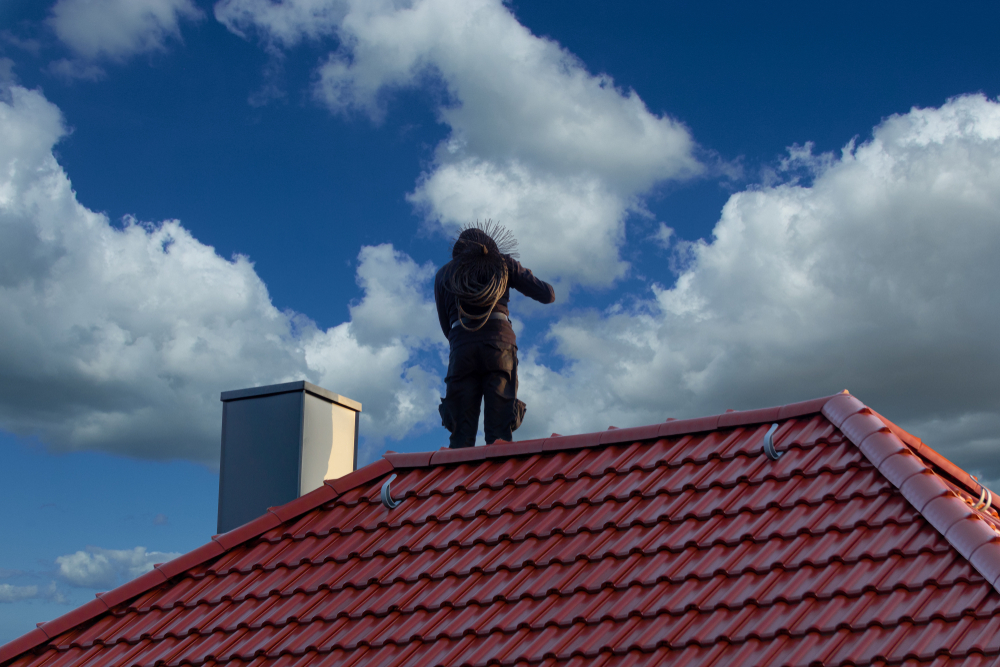 Chimney,sweeper,on,the,roof,of,a,house,in,an