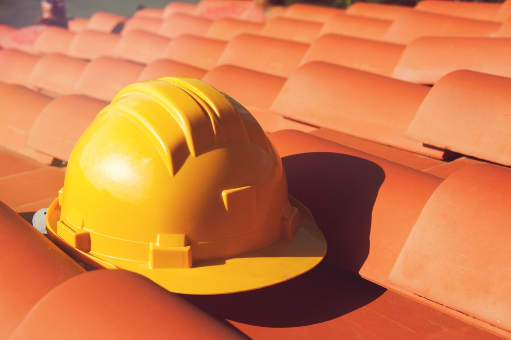 Professional,yellow,hard,hat,on,a,house,roof,.,construction