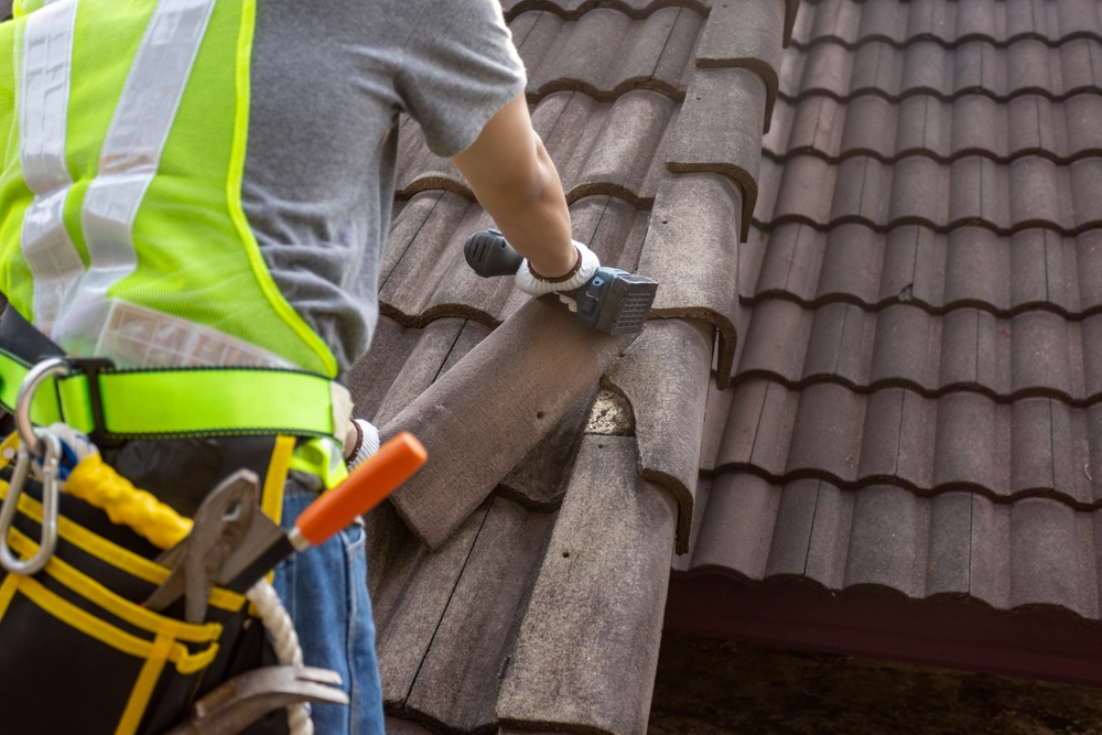 Worker,man,replace,tile,of,the,old,roof.,repair,roof