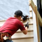 Young,homeowner,installs,siding,to,his,home.,he,is,holding