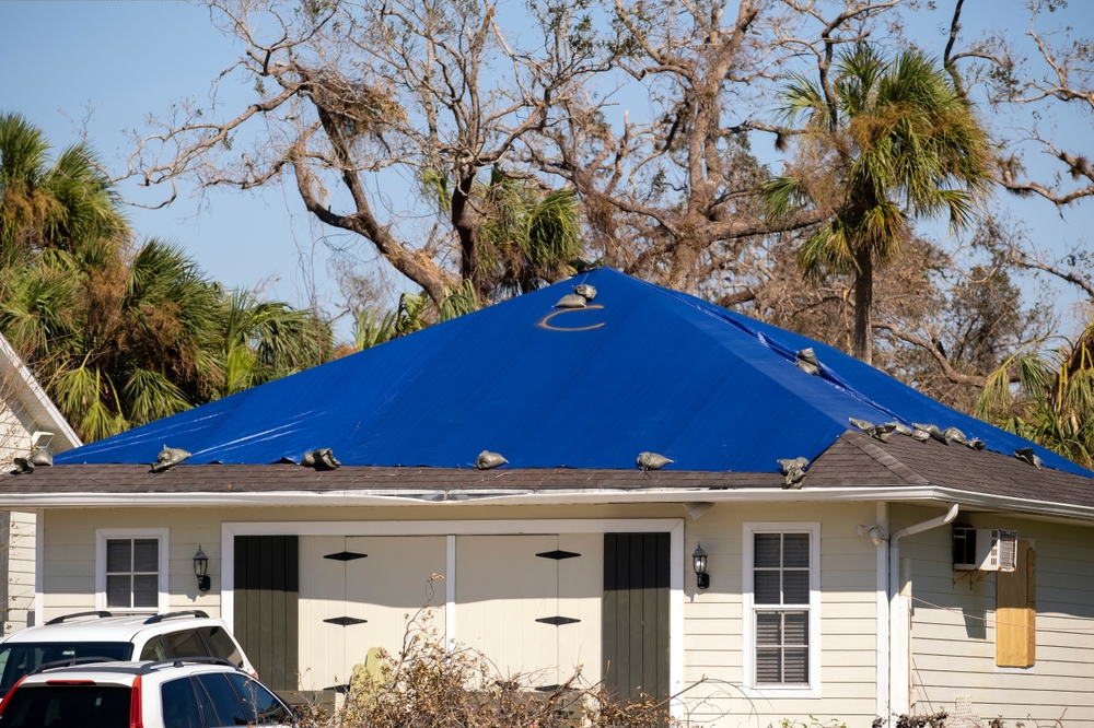 Hurricane,ian,damaged,house,rooftop,covered,with,protective,plastic,tarp