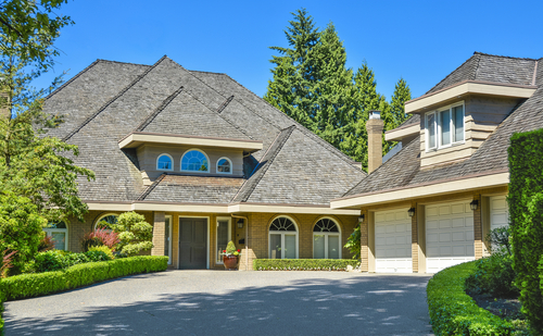 Residential,house,with,massive,roofs,,green,hedge,in,front,on